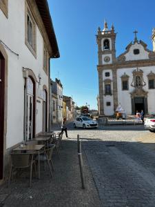 a street with tables and chairs and a building with a clock tower at Apartamento matriz in Póvoa de Varzim