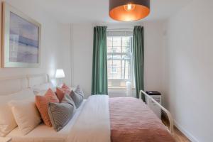 a bedroom with a white bed and a window at Central Euston One Bedroom Home in London