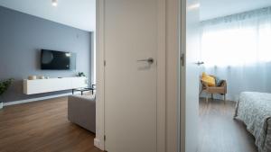 ウエルバにあるApartamento Luis de Vargasのベッド、テレビ、ソファが備わる客室です。