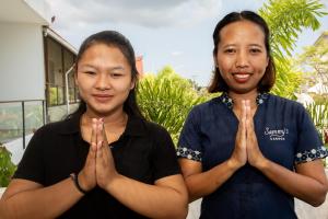 坎古的住宿－Sammy's Canggu，两个年轻的女人站在祈祷的姿势中