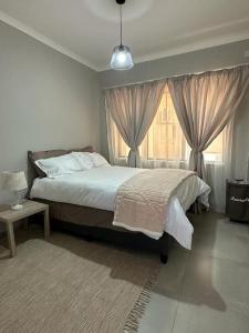 ein Schlafzimmer mit einem großen Bett und einem Fenster in der Unterkunft The Urban Hub in Block 5 in Gaborone