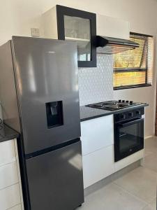 a kitchen with a stainless steel refrigerator and a stove at The Urban Hub in Block 5 in Gaborone