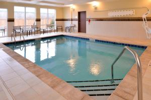 a pool in a hotel with chairs and tables at Courtyard by Marriott Toledo North in Toledo