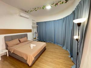 ein Schlafzimmer mit einem Bett und einem blauen Vorhang in der Unterkunft CozySuite@ SUN GEO & Linked to Sunway Medical, Sunway Uni & Sunway Pyramid in Petaling Jaya