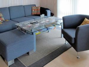 a living room with a blue couch and a glass table at 6 person holiday home in Hals in Hals