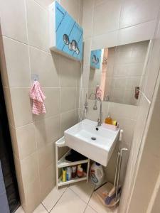 ein kleines Bad mit einem Waschbecken und einem Spiegel in der Unterkunft CozySuite@ SUN GEO & Linked to Sunway Medical, Sunway Uni & Sunway Pyramid in Petaling Jaya