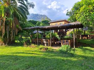 une personne assise sous un pavillon dans une cour dans l'établissement Blend Lodge and Kitchen - Pakachere, à Zomba