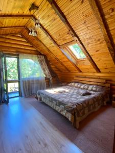 a bedroom with a bed in a wooden cabin at Sofiya in Mykulychyn