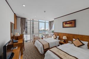 Cette chambre comprend deux lits et une télévision. dans l'établissement Danang Petro Hotel, à Đà Nẵng