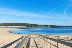 a dock on a beach with blue water at Calma na Lagoa de Albufeira, Castelo Sesimbra. in Sesimbra