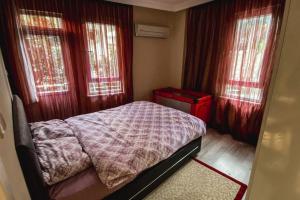 a small bedroom with a bed and two windows at "Kale Street" Alanya in Alanya