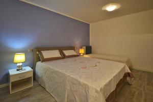 ein Schlafzimmer mit einem Bett und einem Nachttisch mit zwei Lampen in der Unterkunft Appartamento Enrichetta in Manerba del Garda