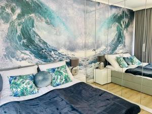 a bedroom with a large wave mural on the wall at HO!HOUSE SHELLTER ROGOWO in Rogowo