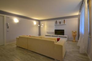 ein Wohnzimmer mit einem Sofa und einem TV in der Unterkunft Appartamento Enrichetta in Manerba del Garda