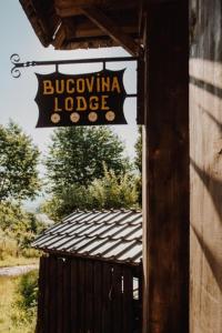 Bucovina Lodge Pension في فاما: علامة على جانب المبنى