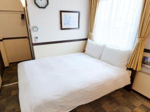 a bed in a room with a window at Toyoko Inn Osaka Shinsaibashi Nishi in Osaka