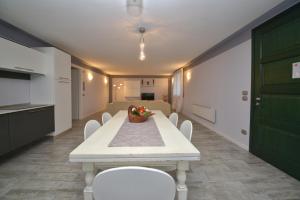 Zimmer mit einem Tisch, weißen Stühlen und einer grünen Tür in der Unterkunft Appartamento Enrichetta in Manerba del Garda