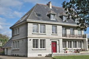 a large brick house with a red door at Manoir de Kerguestenen in Gestel