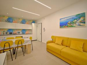 a living room with a yellow couch and a table at ApartmentsArena - Residenza Dei Doganieri - Verona in Verona
