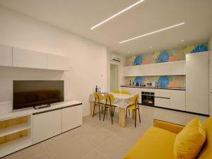 a kitchen and dining room with a table and yellow chairs at ApartmentsArena - Residenza Dei Doganieri - Verona in Verona