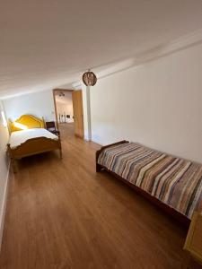 a bedroom with a bed and a wooden floor at Casa Bé-Bia in Carvalhal +46 photos