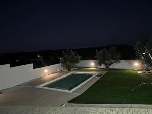 a backyard with a swimming pool at night at Casa Bé-Bia in Carvalhal