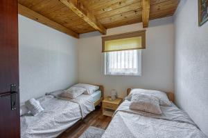 two twin beds in a room with a window at Plitvice Lakes House By The Creek - Happy Rentals in Korenica +17 photos