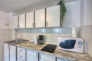 a kitchen with a sink and a microwave at Plitvice Lakes House By The Creek - Happy Rentals in Korenica