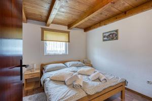 a bedroom with a bed and a wooden ceiling at Plitvice Lakes House By The Creek - Happy Rentals in Korenica