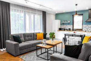 a living room with a couch and a table at Apartamenty Pod Kominkiem in Rydzewo