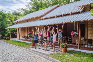 eine Gruppe von Menschen, die auf der Veranda eines Hauses springen in der Unterkunft Society House Luxury Hostel in Pai