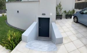 a white building with a blue door in a yard at The Roundhouse in Paleo Tsifliki