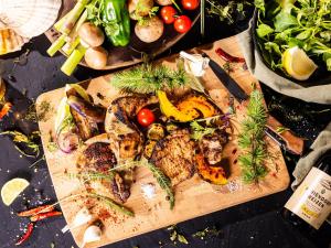 una tabla de cortar con carne y hortalizas sobre una mesa en Tokachi Nakasatsunai Glamping Resort Feriendorf en Naka-satsunai