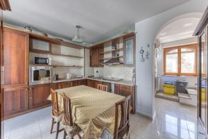 una cocina con armarios de madera y una mesa con sillas. en Casa di Marika, en Marina di Leuca