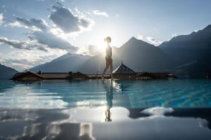 a woman standing on the edge of a body of water at Hotel Sunnwies in Schenna