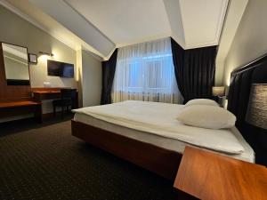 ワルシャワにあるWilla Pirsのベッドとデスクが備わるホテルルームです。