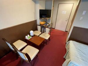 a room with two chairs and a table and a bed at Gora Hotel Paipuno Kemuri Plus in Hakone
