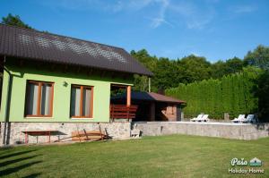 ein grünes Haus mit einem Tisch und einer Bank im Hof in der Unterkunft Holiday Home Paša in Zolaći