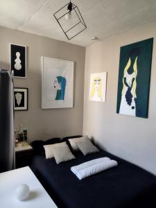 a bedroom with a bed and paintings on the wall at Studio moderne, propre et calme in Melun