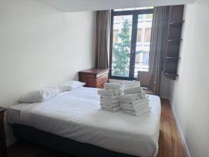 een slaapkamer met een bed met handdoeken erop bij Smartflats - Residence Collector in Brussel