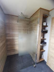 y baño con ducha y paredes de madera. en Baumhaus und Tinyhaus, en Felchta