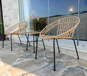 dwa krzesła i stół przed oknem w obiekcie ReCrete w Heraklionie