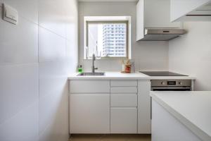 a white kitchen with a sink and a window at Frank Porter - The Medalist in Dubai