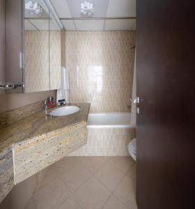 a bathroom with a sink and a toilet and a mirror at Frank Porter - The Medalist in Dubai