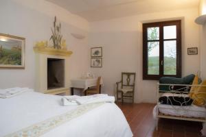 um quarto com uma cama, uma lareira e uma janela em Agriturismo Il Buonvicino em Cassine