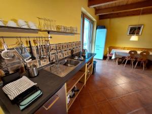 cocina con encimera, fregadero y mesa en Cascina Nomade, en Dogliani