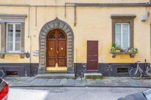 Lucca Historic & Cozy Central Apartment! في لوكّا: مبنى فيه باب خشبي ونافذة