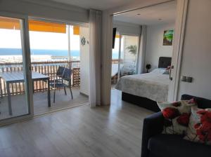a bedroom with a bed and a balcony with the ocean at Apartamento con vistas in Blanes