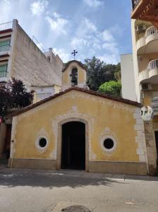 a small church with a cross on top of it at Apartamento con vistas in Blanes