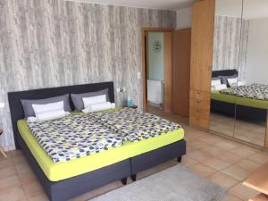 a bedroom with a large bed and a mirror at HappyTime in Eriskirch